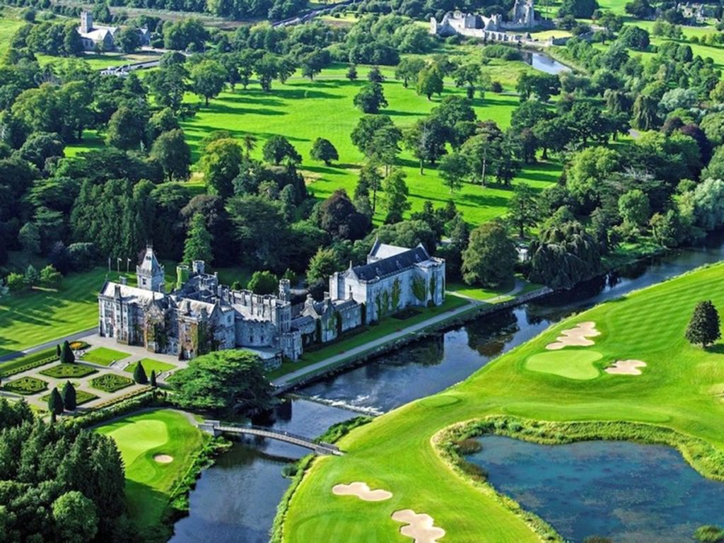 A large castle sits on top of a lush green hillside.