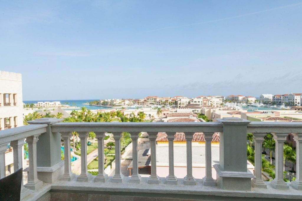 A balcony with a view of the ocean and buildings.