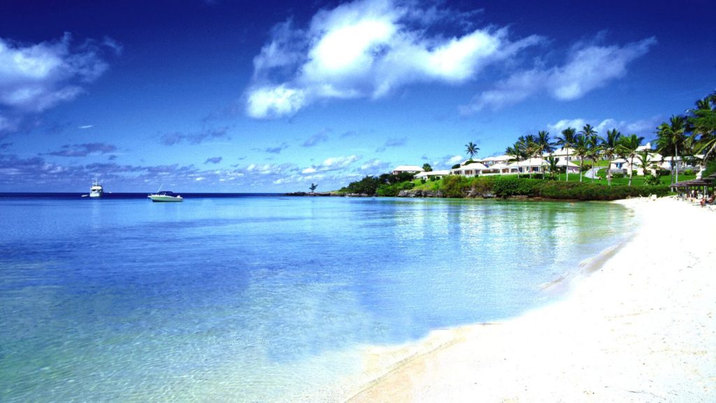 A beach with some water and buildings in the background