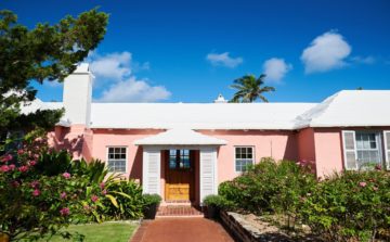 A pink house with a white roof and door.