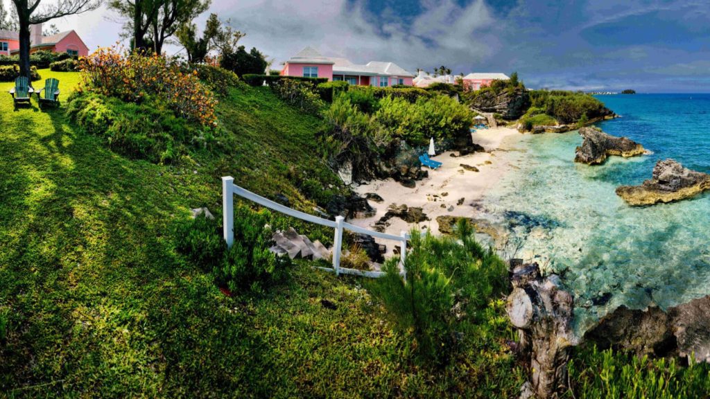 A beach with people walking on it and trees