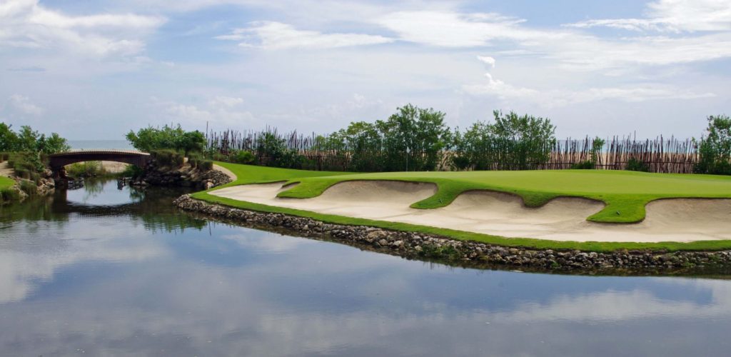 A golf course with sand traps and water.