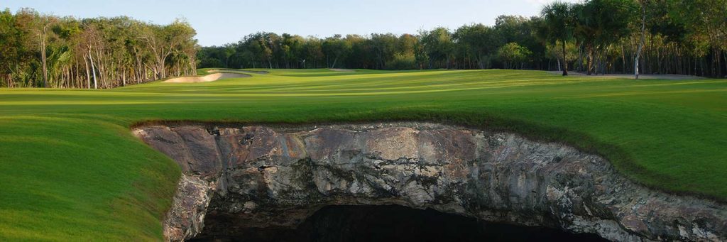 A view of the green from behind a rock wall.