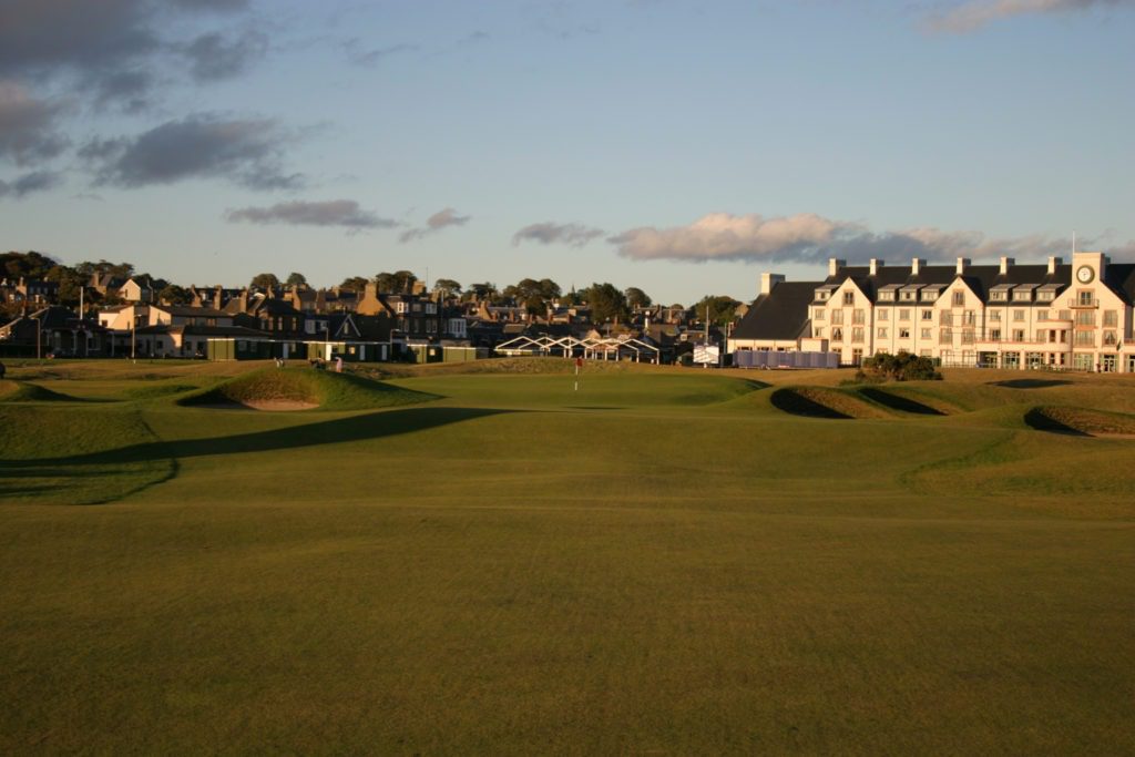 A golf course with houses in the background.