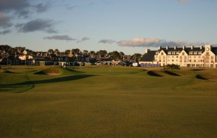 A golf course with houses in the background.