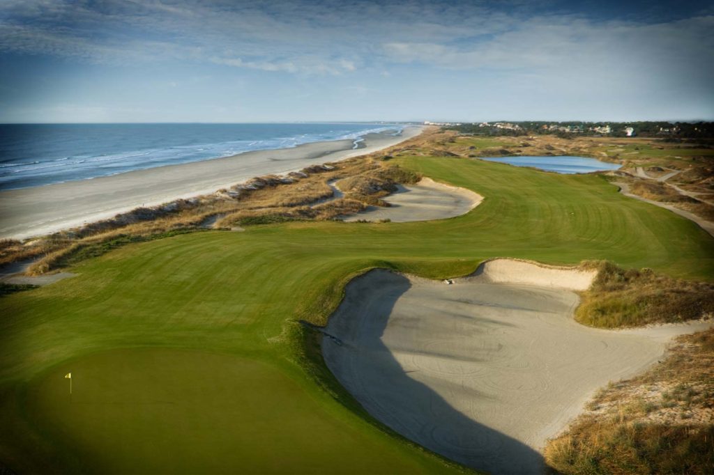 A view of the ocean from above, showing a golf course.