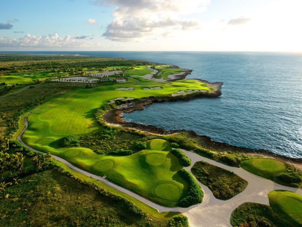 A view of the ocean from above, with a golf course.