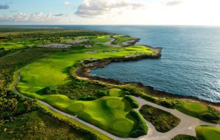 A view of the ocean from above, with a golf course.
