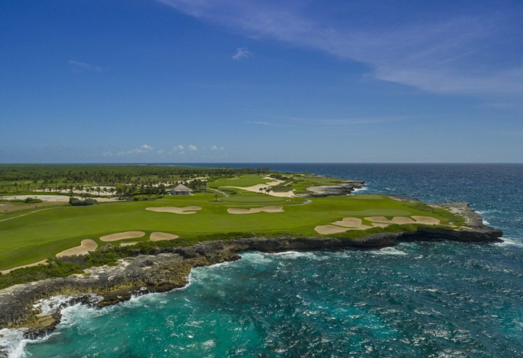 A view of the ocean from above, showing a golf course.