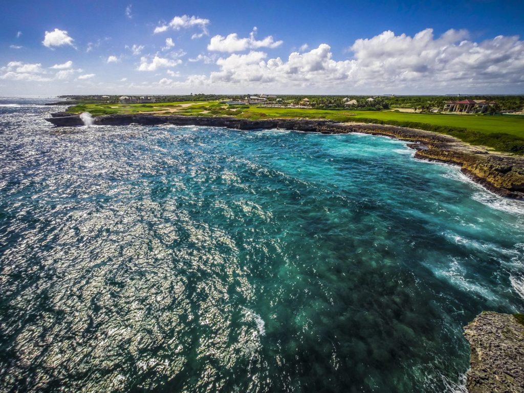 A body of water with blue water and green grass.