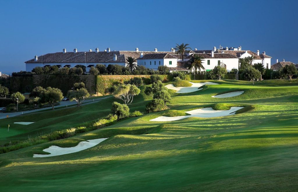 A golf course with many green areas and buildings.