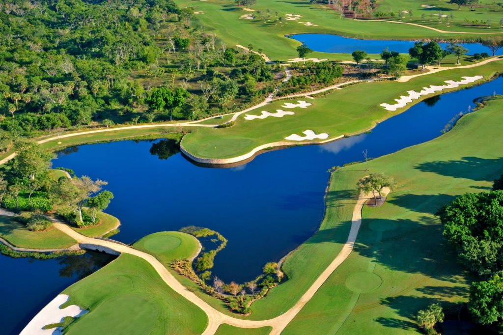 A golf course with many trees and water