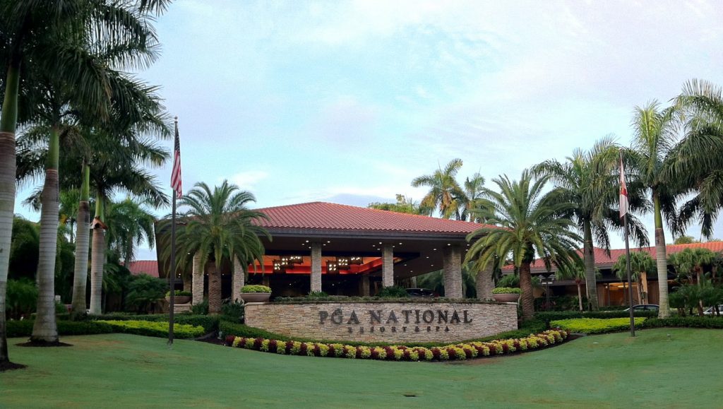 A large building with palm trees in front of it.