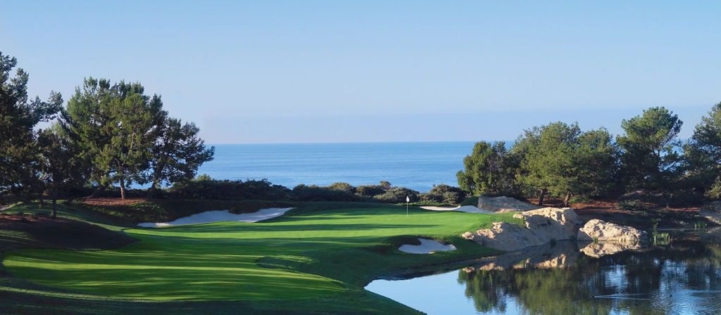 A view of the ocean from behind a golf course.