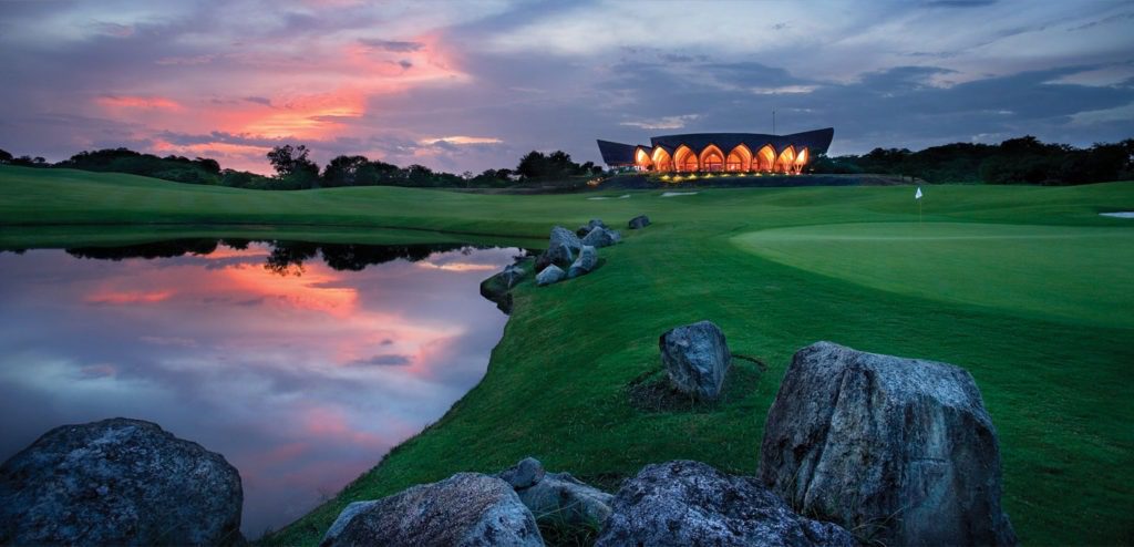 A golf course with a building in the background.