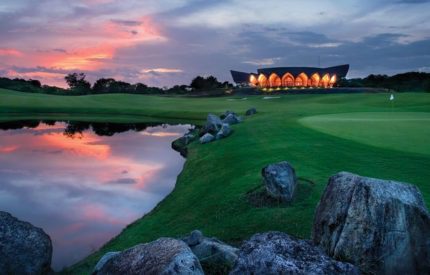 A golf course with a building in the background.