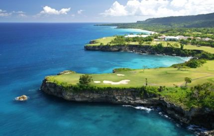 A view of the ocean from above, with a golf course.