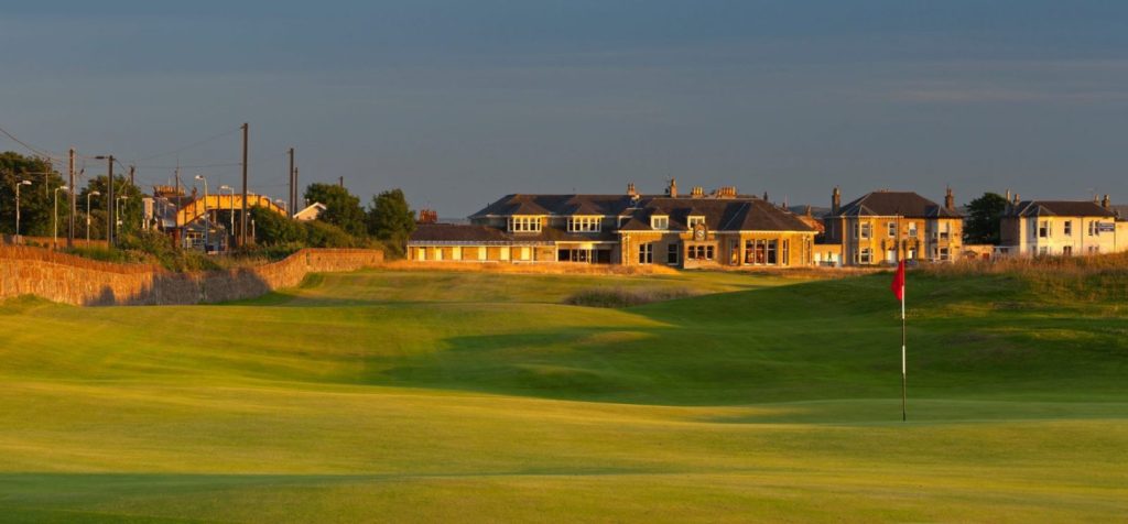 A large building sits on the side of a golf course.