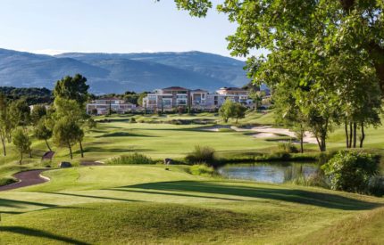 A golf course with houses in the background.