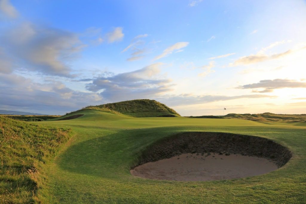 A golf course with sand traps and green.