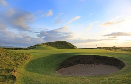 A golf course with sand traps and green.
