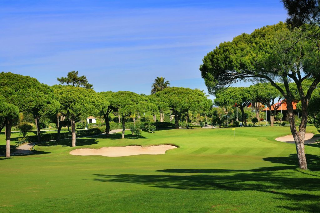 A golf course with trees and sand traps.