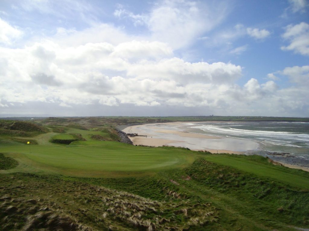 A view of the ocean from above, with a golf course.