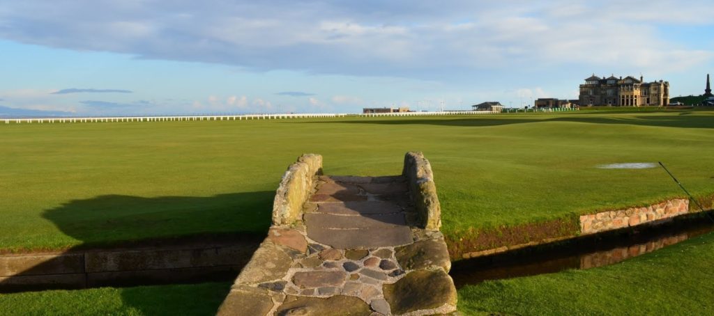 A stone bridge over the water at a golf course.