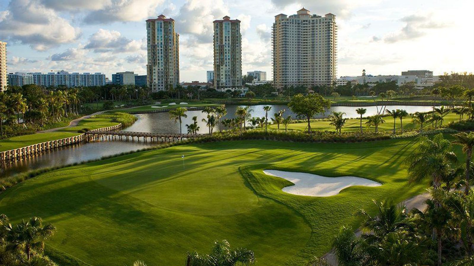 A golf course with many buildings in the background.