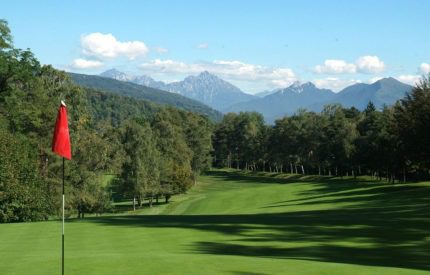 A view of the golf course with mountains in the background.