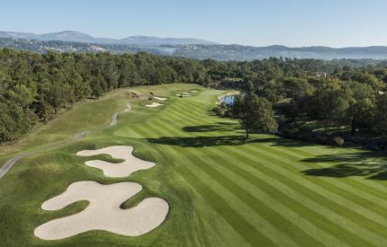A golf course with many green areas and trees.