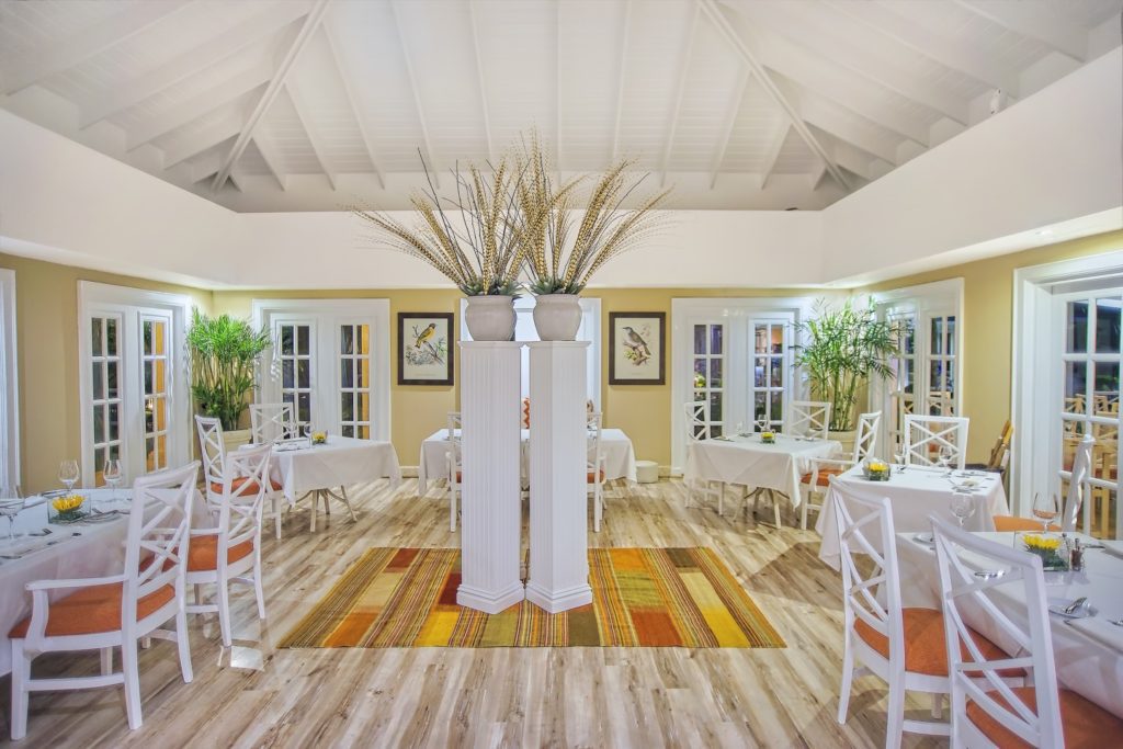 A restaurant with white chairs and tables in it