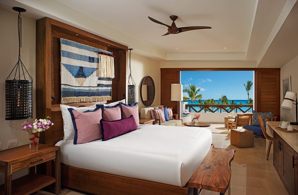 A bedroom with a large bed and a view of the ocean.