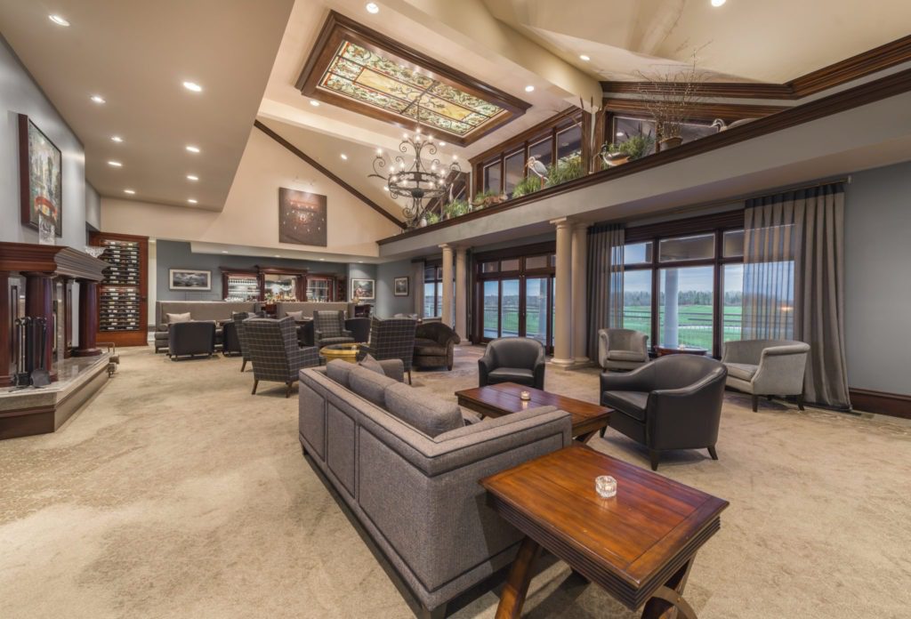 A living room filled with furniture and large windows.