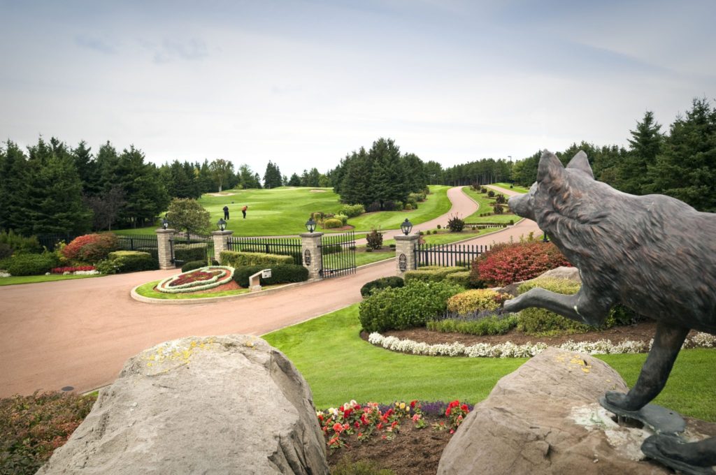 A bird statue in the middle of a garden.