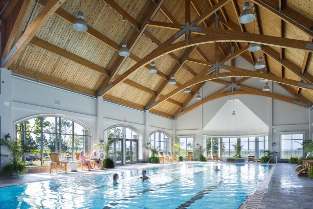 A large indoor swimming pool with people in it.