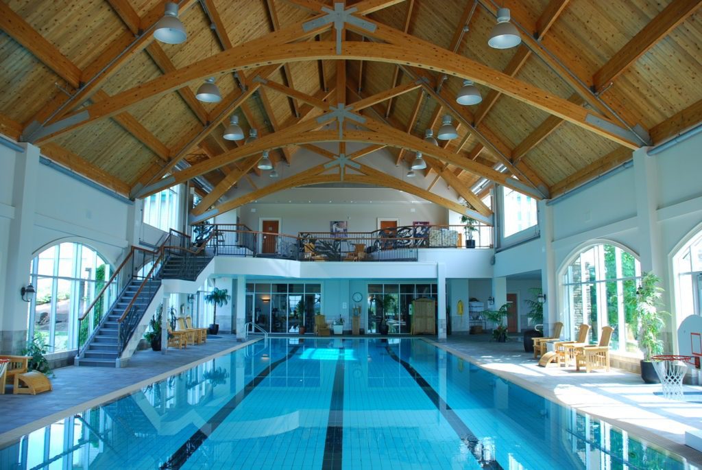 A large indoor swimming pool with wooden beams.