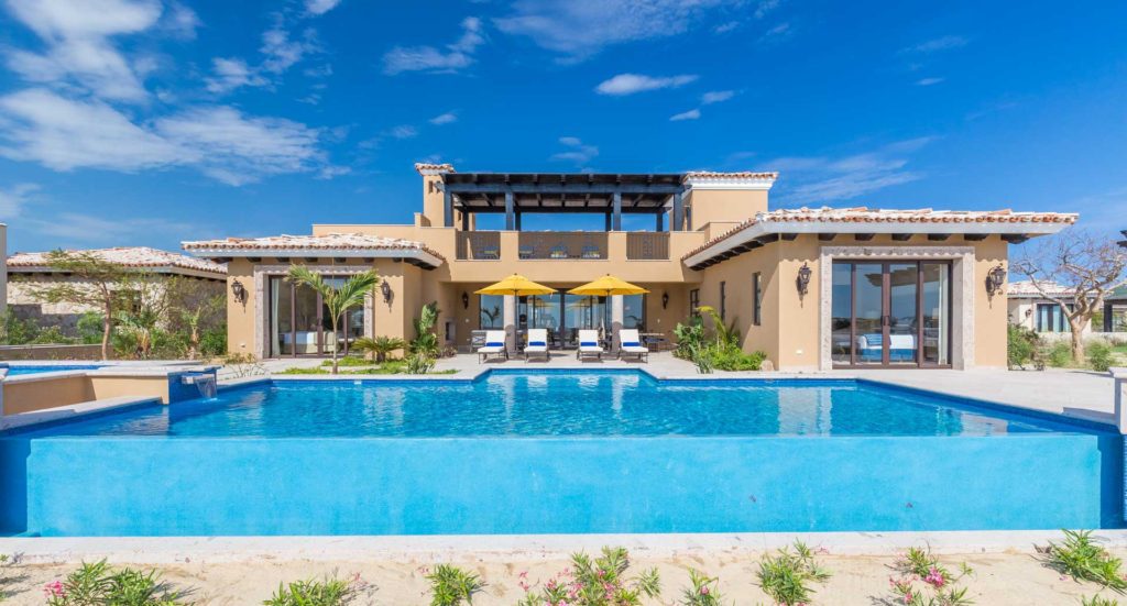 A large pool with chairs and umbrellas in the background.