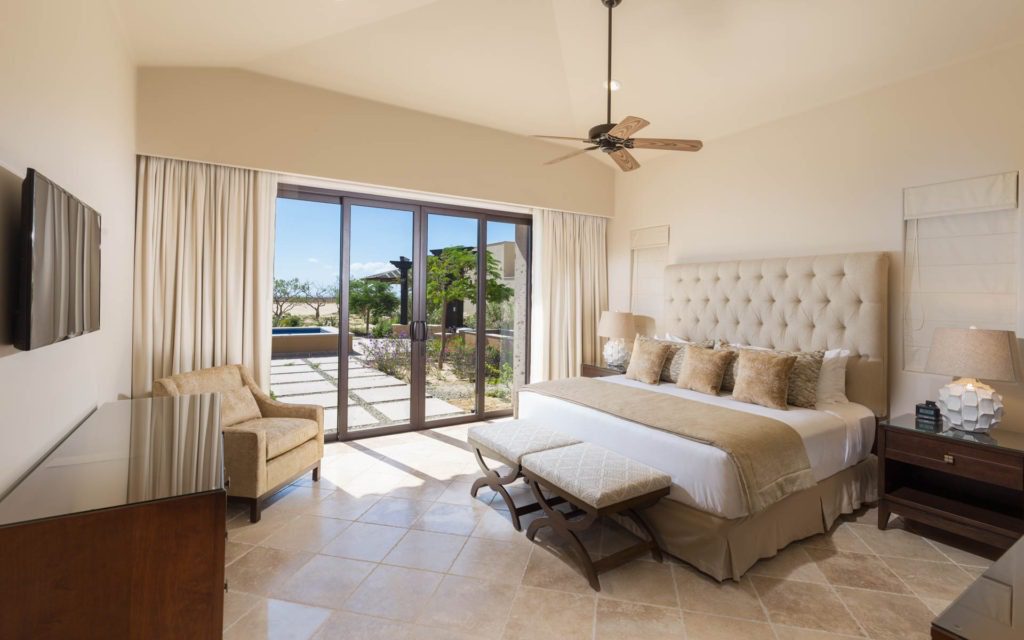 A bedroom with a large bed and sliding glass doors.