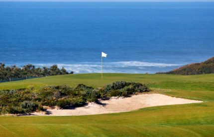 A golf course with sand traps and flag in the middle.