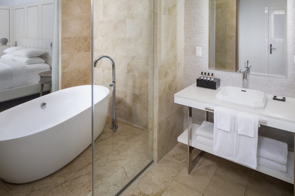 A bathroom with a tub, sink and shower.