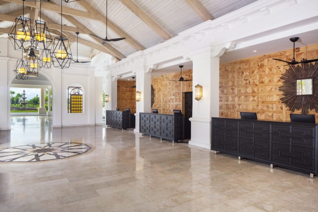 A large lobby with many black counters and white walls.