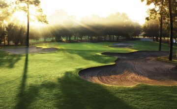 Sunrise over a golf course with sand traps.