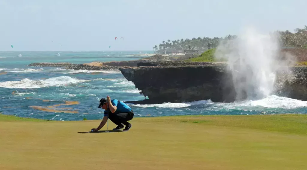 Golfer putting on a coastal course.